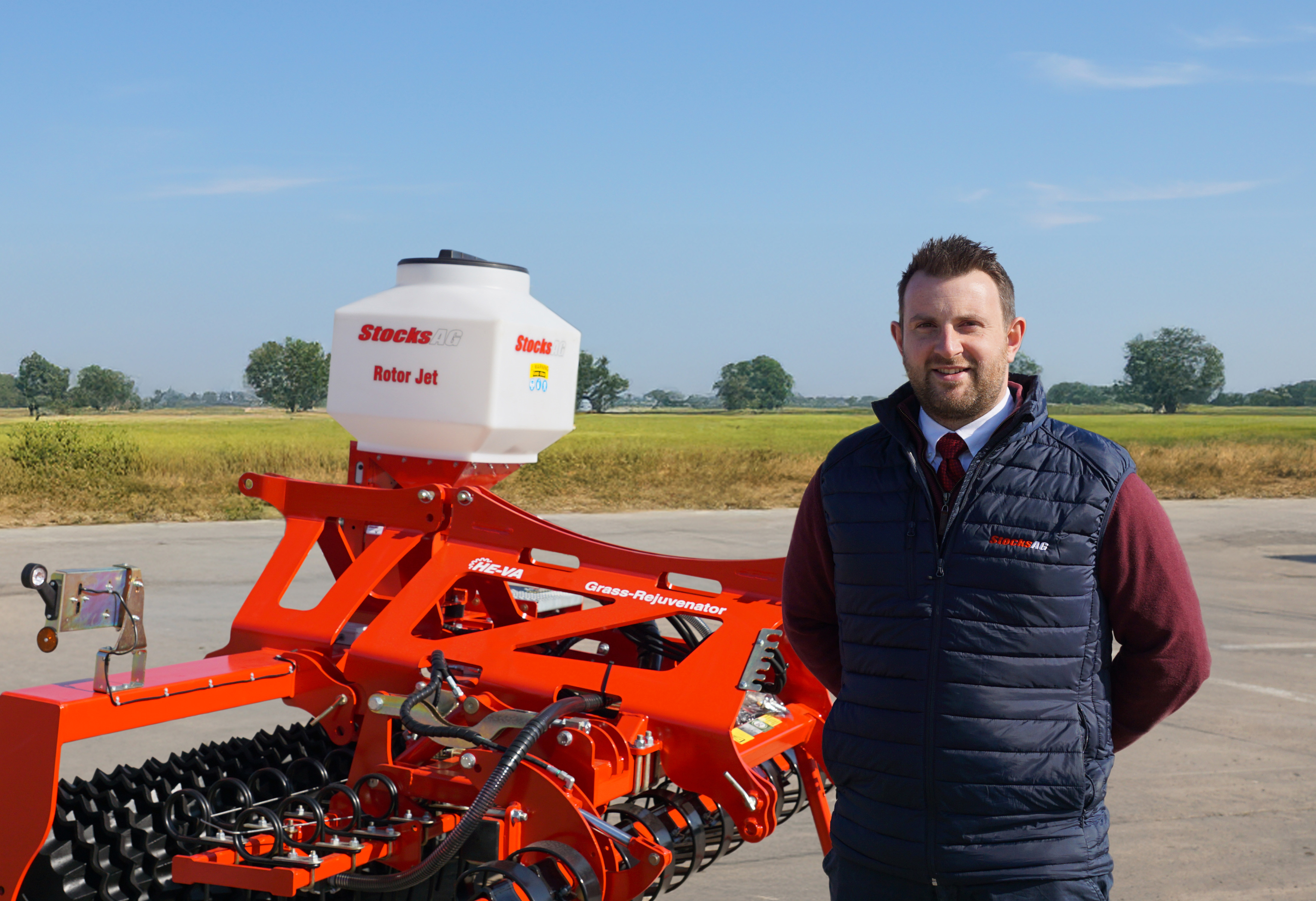 Will Fowler stood with Stocks Ag Rotor Jet applicator mounted to a HE-VA Grass Rejuvenator
